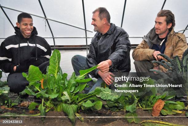 Capital District Community Gardens farmer/educator Brian Bender, center, with Troy High student Steven Cochran left, and volunteer/mentor Cal Egan of...