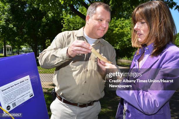 State Forester Rob Davies, left, shows an example of the damage done to ash trees by the Emerald Ash Borer to Natural Resources Assistant...