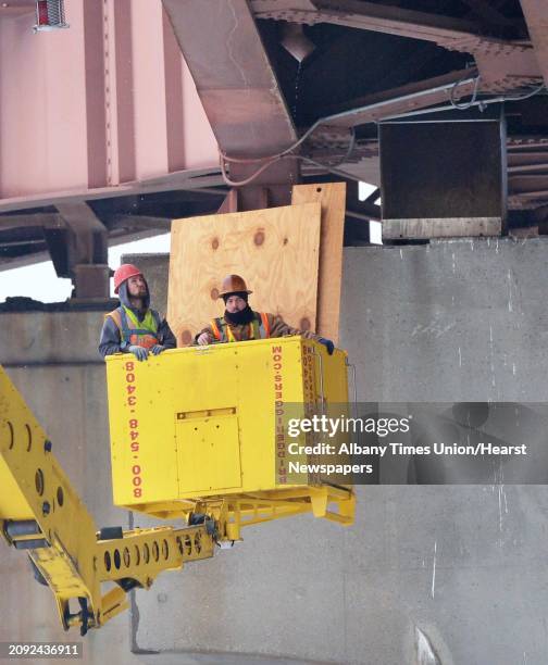 Workers remove covers from peregrine falcon nesting boxes, pictured right, on Dunn Memorial Bridge Tuesday Jan. 29 in Albany, N.Y. The screening was...