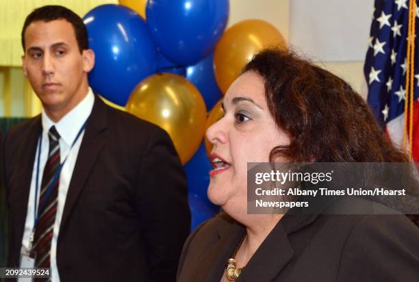 Ferdinand Morales, operations VP at the Maximus call center, left, listens as Donna Frescatore, Executive Director of NY State of Health, speaks at a...