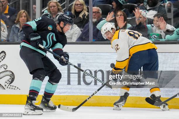 Brian Dumoulin of the Seattle Kraken and Tommy Novak of the Nashville Predators battle for the puck along the boards during the third period of a...
