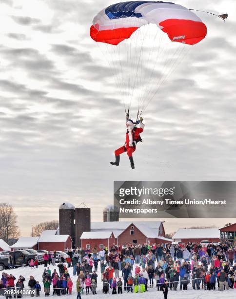 Santa Claus parachutes onto the Ellms' Christmas Tree Farm as a 1000 eager onlookers cheer Saturday Nov. 29, 2014.