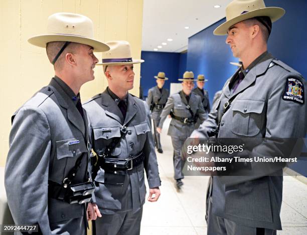 Trooper recruits Tyler Moffatt, left, Vaske Zhaka of Albany and Gary Holle of Loudonville, right, before the start of graduation exercises at the...