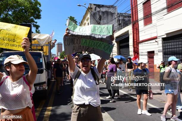 University student holds a banner that reads "Corruption goes backwards when education goes forward" during a protest near the National Congress over...