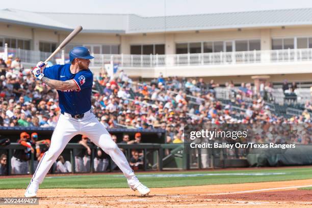 Jonah Heim of the Texas Rangers bats during a spring training game against the San Francisco Giants at Surprise Stadium on February 25, 2024 in...