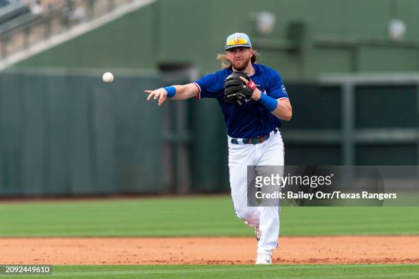 Davis Wendzel of the Texas Rangers fields the ball during a spring training game against the San Francisco Giants at Surprise Stadium on February 25,...