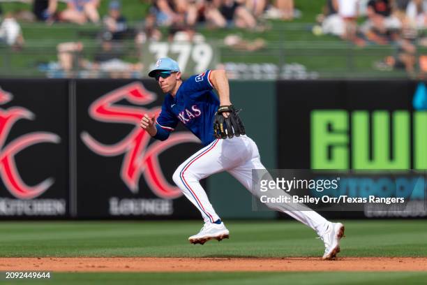 Matt Duffy of the Texas Rangers runs to make a play during a spring training game against the San Francisco Giants at Surprise Stadium on February...