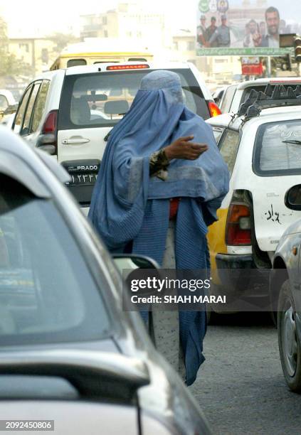 An Afghan woman beggar begs on a road in Kabul, 24 October 2005. Afghanistan's election authority announced 23 October the remaining provisional...