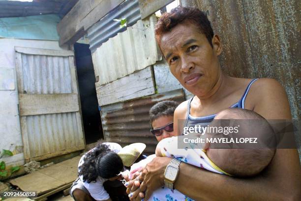 La nicaragüense Vilma Martínez arrulla a su nieto Romel Mojica el 23 de julio de 2004 frente a su casa ubicada en el sector conocido como "Cuencas de...