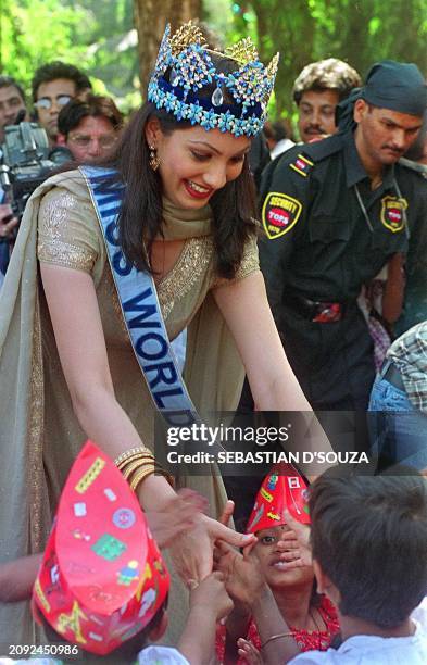 Newly crowned Miss World, Yukta Mookhey, is greeted by orphan children at the Mankhurd Children's Home 15 December, 1999 in Bombay following her...