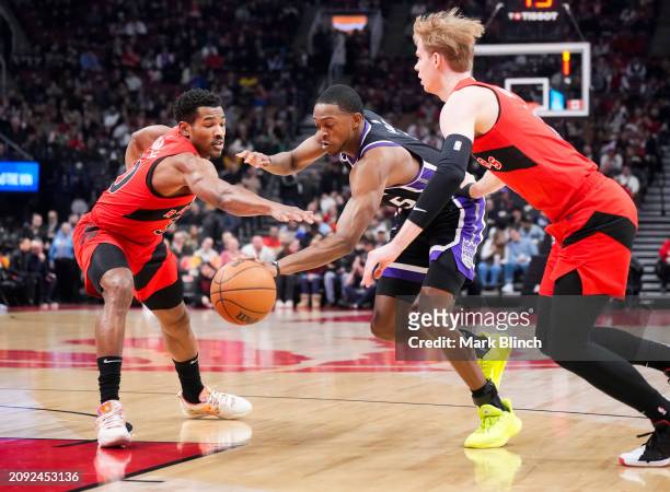 De'Aaron Fox of the Sacramento Kings drives against Ochai Agbaji and Gradey Dick of the Toronto Raptors during the first half at the Scotiabank Arena...
