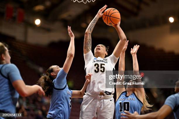 Sacha Washington of the Vanderbilt Commodores drives to the basket in the first half against Cecelia Collins and Kitty Henderson of the Columbia...