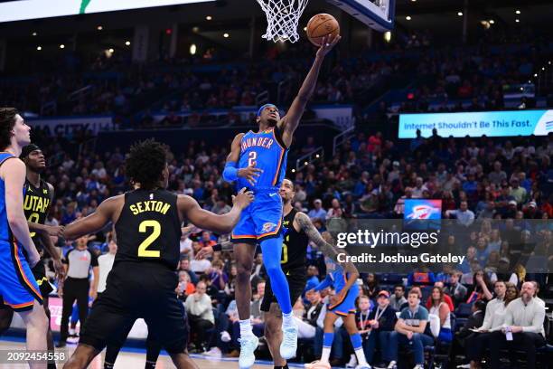 Shai Gilgeous-Alexander lays up a shot at the basket during the second half against the Utah Jazz at Paycom Center on March 20, 2024 in Oklahoma...