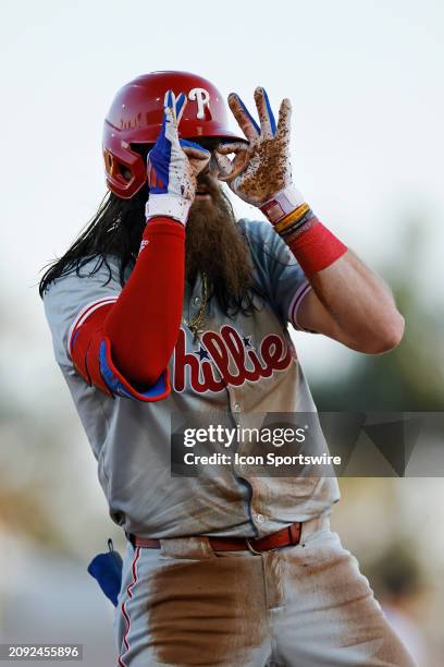 Philadelphia Phillies left fielder Brandon Marsh reacts after hitting an RBI triple in the third inning of an MLB spring training game against the...