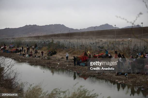 Border patrol officers pull barbed wires as migrants cross the Rio Grande river to surrender to the American authorities on March 20 in Ciudad...