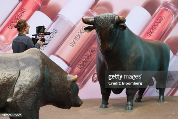 Hoardings featuring Douglas AG products near the Bull and Bear statues outside the Frankfurt Stock Exchange, ahead of the company's initial public...