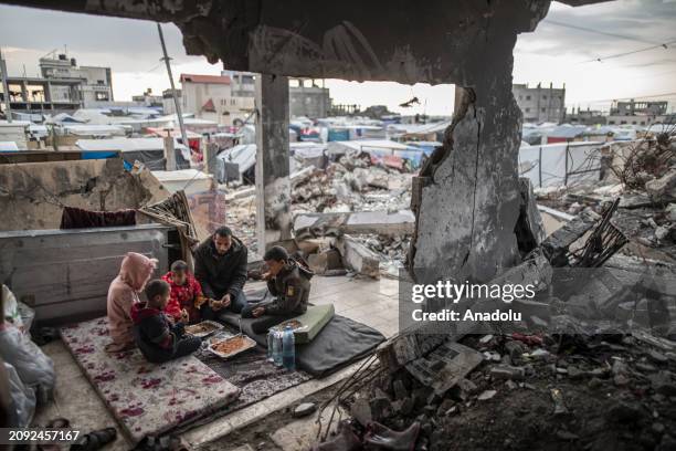 Palestinian Muhammad al-Durra, whose house was destroyed in the Israeli attack and who lost his wife, breaks his fast on the floor he prepares with...