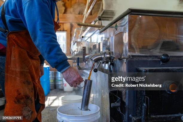 Pat LeClaire pours freshly made maple syrup from an evaporator into a beaker to measure its density March 8, 2024 in Charlotte, Vermont. Fresh maple...