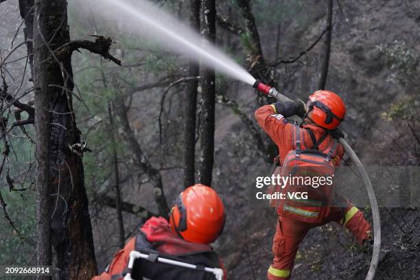 Firefighters work at the site of a forest fire near Baizi village on March 17, 2024 in Yajiang County, Garze Tibetan Autonomous Prefecture, Sichuan...