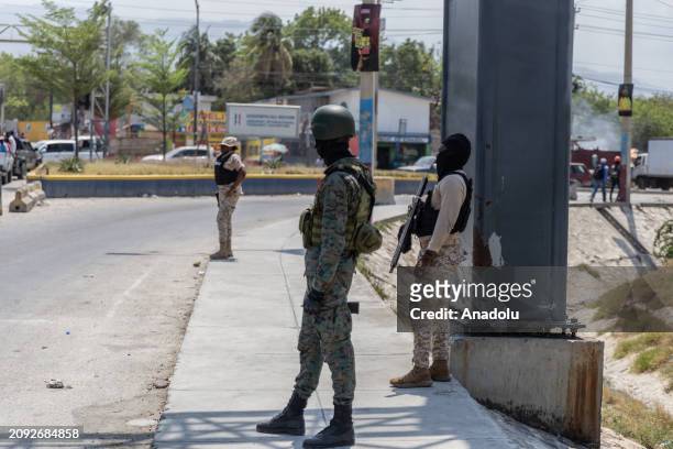 View of Haitian police and soldiers on patrol at the entrance to Toussaint Louverture international airport in Port-au-Prince, as panic in the...