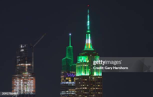 The Empire State Building and One Vanderbilt are illuminated in green to mark St. Patrick's Day in New York City on March 17 as seen from Jersey...