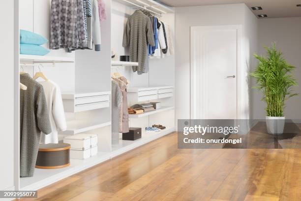 close-up view of closet with shoes and hanging clothes. modern dressing room - kast stockfoto's en -beelden