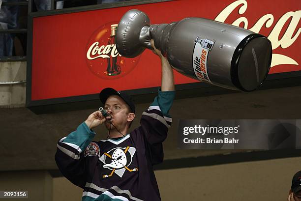 Fan of the Anaheim Mighty Ducks waves a Cup replica as he rallies the team on during the Game Six of the 2003 Stanley Cup Finals against the New...