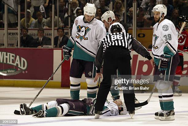 Teams watch over as Paul Kariya of the Anaheim Mighty Ducks lies on the ice after being hit by Scott Stevens of the New Jersey Devils during the...