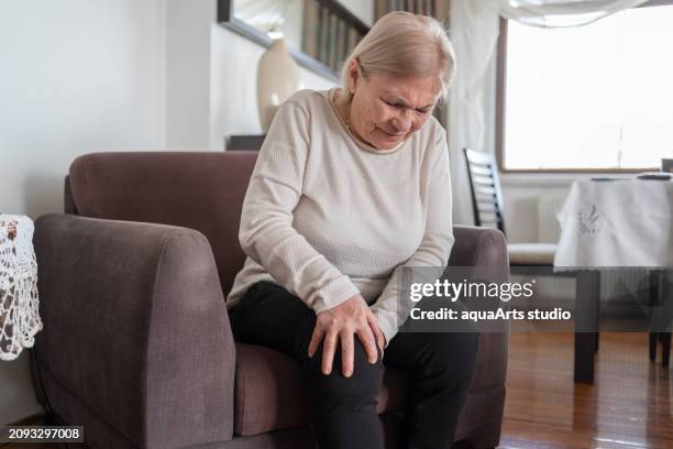 seniorin mit knieschmerzen - gelenkrheumatismus stock-fotos und bilder