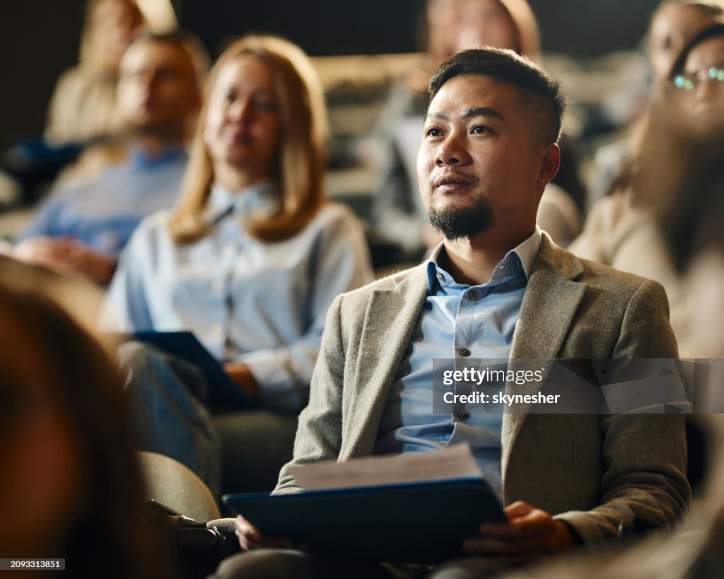 Chinese businessman attending an education event in convention center.