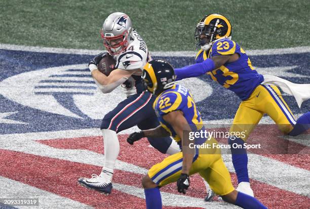 Rex Burkhead of the New England Patriots running with the ball pursued by Marcus Peters and Nickell Robey-Coleman of the Los Angeles Rams in the...