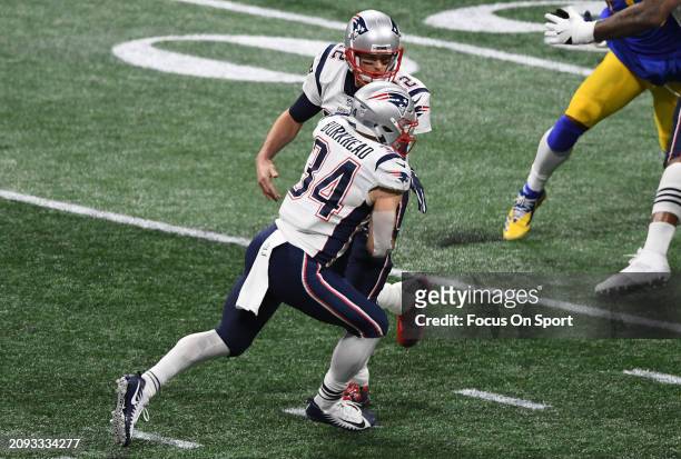 Tom Brady of the New England Patriots turns to handoff to running back Rex Burkhead against the Los Angeles Rams in the first half of Super Bowl LIII...