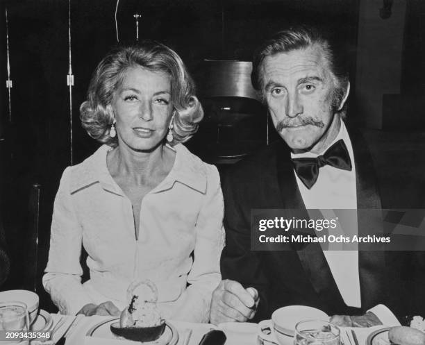 German-born American film producer Anne Buydens, wearing a white outfit with matching white jacket, and her husband, American actor and film director...