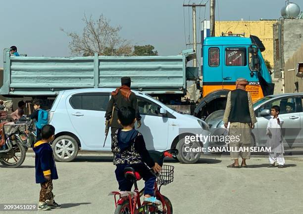 An Afghan security personnel checks a vehicle near the site of a suicide bomb attack in Kandahar on March 21, 2024. A suicide bombing killed at least...