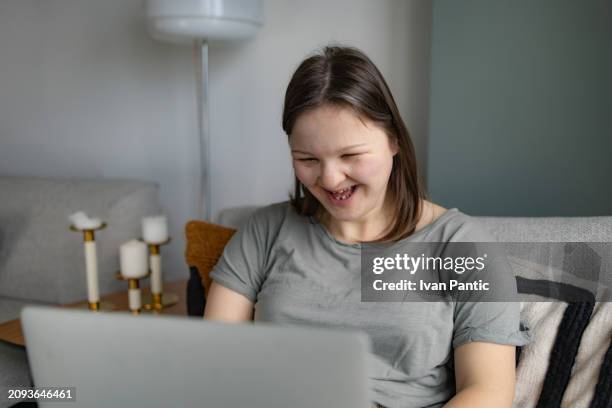 cheerful woman with special needs having fun while using laptop at home. - disability computer stock pictures, royalty-free photos & images