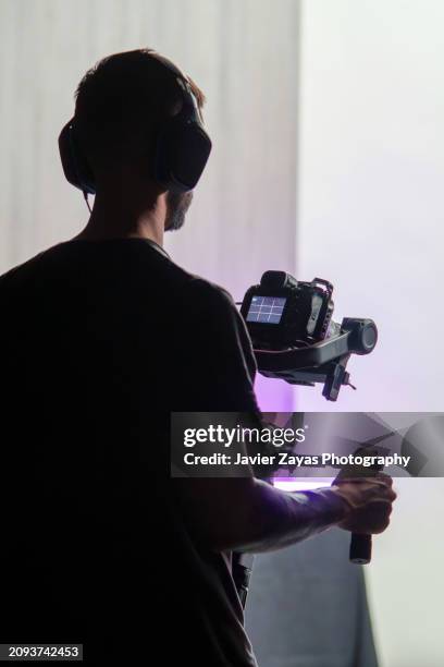 camera man at work using gimbal (indoors) - cameraman foto e immagini stock