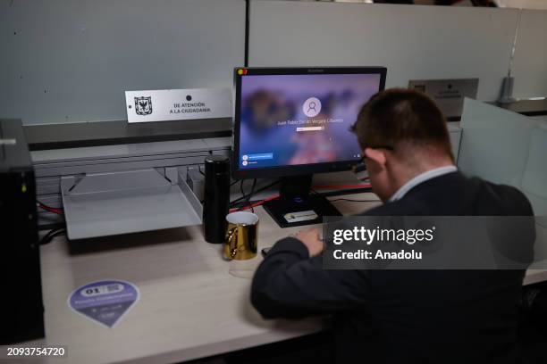 Juan Pablo Dimitri Vergara Cifuentes looks at his computer at his office where he works as the first public official in Bogota with Down syndrome for...