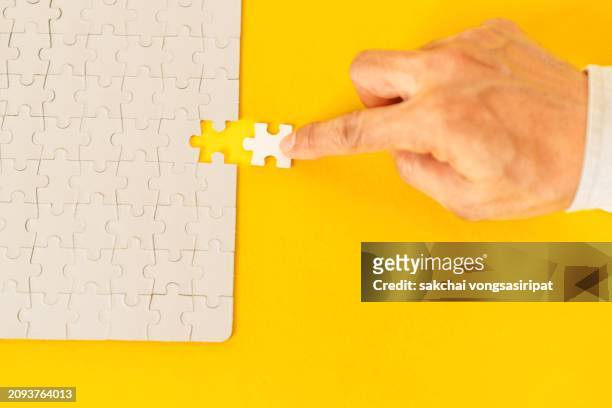 a final jigsaw puzzle piece into a last blank, iq test, successful problem solving concept - finals game one stock pictures, royalty-free photos & images