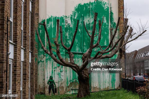 Members of the public photograph a recent mural which has appeared on the side of a building in Islington on March 18, 2024 in London, England. The...