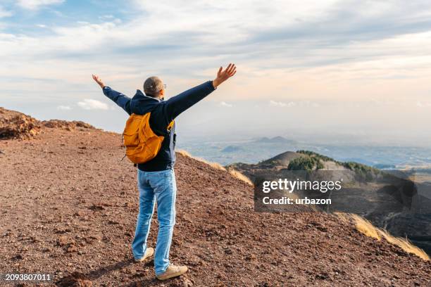 young man enjoying the view on mount etna in sicily in catania in italy - etna stock pictures, royalty-free photos & images