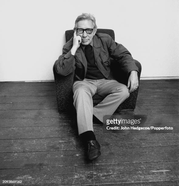 English poet, novelist and writer Laurie Lee posed seated in an armchair in a studio at the Royal College of Art in Kensington, London in 1983.