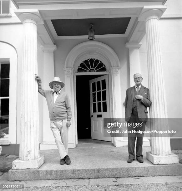 English novelist, poet and playwright William Golding stands on left with British historian A. L. Rowse outside Golding's home, Tullimaar House near...