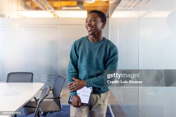 happy young businessman standing in conference room at startup office - fotografia de três quartos imagens e fotografias de stock