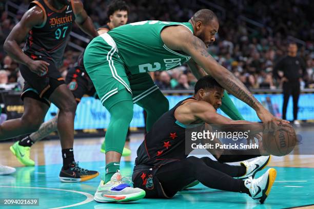 Jared Butler of the Washington Wizards and Xavier Tillman of the Boston Celtics battle for a loose ball during the first half at Capital One Arena on...
