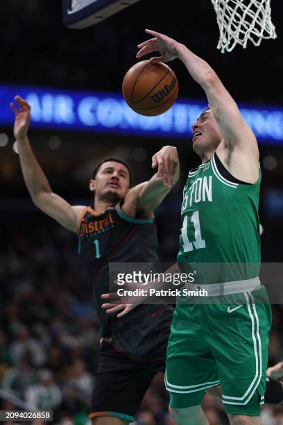 Payton Pritchard of the Boston Celtics and Johnny Davis of the Washington Wizards battle for a rebound during the second half at Capital One Arena on...