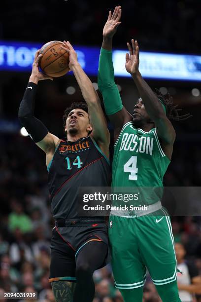 Jules Bernard of the Washington Wizards shoots in front of Jrue Holiday of the Boston Celtics during the first half at Capital One Arena on March 17,...