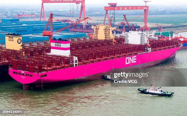 Container ship is assisted by tugboats as it prepares to leave a dockyard of Jiangsu Yangzi-Mitsui Shipbuilding Co., Ltd. On March 18, 2024 in...