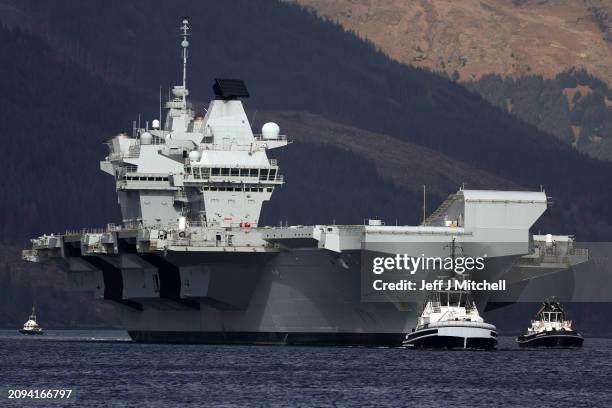 Queen Elizabeth air craft carrier is pulled by tugs on Loch Long on March 18, 2024 in Glenmallan, Scotland. HMS Queen Elizabeth was in Glenmallan in...