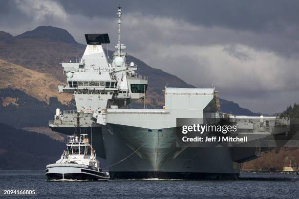 Queen Elizabeth air craft carrier is pulled by tugs on Loch Long on March 18, 2024 in Glenmallan, Scotland. HMS Queen Elizabeth was in Glenmallan in...