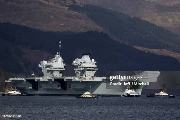 Queen Elizabeth air craft carrier is pulled by tugs on Loch Long on March 18, 2024 in Glenmallan, Scotland. HMS Queen Elizabeth was in Glenmallan in...